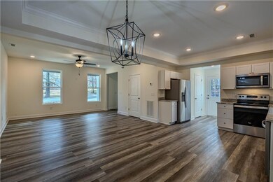 Kitchen featuring light stone countertops, dark ha