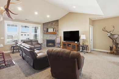 Living room with vaulted ceiling, a fireplace, carpet flooring, and recessed lighting