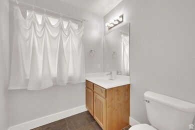 Bathroom with dark tile patterned floors and vanity