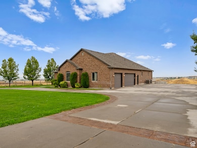View of front of house with concrete driveway, brick siding, and a front lawn