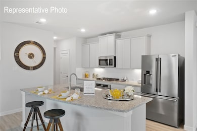 Kitchen featuring an island with sink, tasteful backsplash, light hardwood / wood-style flooring, and stainless steel appliances