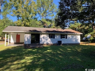 Rear view of house featuring a yard