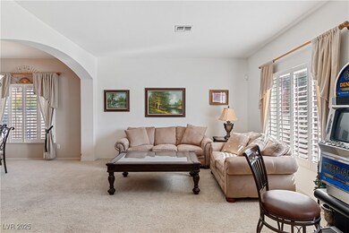 Carpeted living room featuring healthy amount of natural light and arched walkways