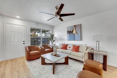 Living room with a textured ceiling, light hardwoo