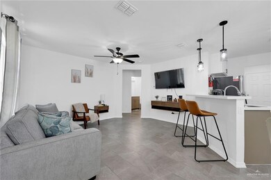 Living area featuring ceiling fan and baseboards