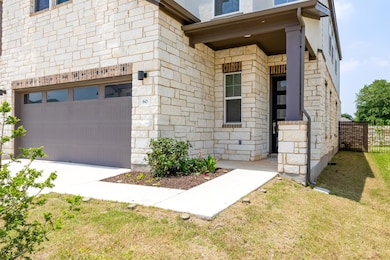 Property entrance featuring fence and stone siding