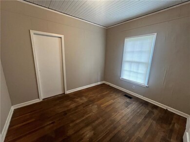 Unfurnished room with dark wood-style floors and baseboards