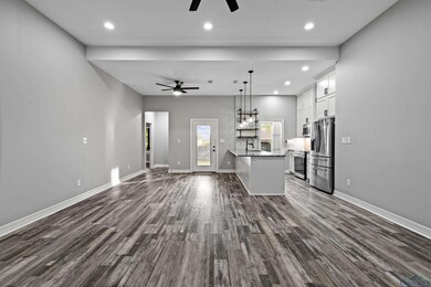 Unfurnished living room with ceiling fan, dark woo