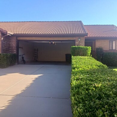 View of front of house featuring brick siding, driveway, a garage, and a tile roof