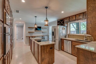 Ceramic-Tiled Island Kitchen Features Abundant Cabinetry, Granite Countertops, Tile Backsplash And Built-In Stainless Appliances