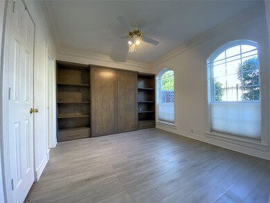 With arched windows, the first bedroom offers a murphy bed. Notice the crown molding.