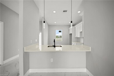 Kitchen featuring light marble finish flooring, recessed lighting, a peninsula, white cabinetry, and tasteful backsplash