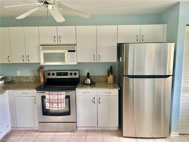 Kitchen with white cabinets, appliances with stain