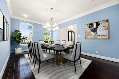 Elegant formal dining room featuring rich hardwood floors, crown molding, and large windows that fill the space with natural light. Perfect for hosting dinner parties or family gatherings in style. *Virtually Staged