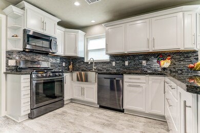 Another view of these elegant KraftMaid  cabinets! The cabinets feature molding at the top of the cabinets, pull out drawers for pots and pans, pull out drawer for your trash can, and custom shelves.