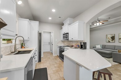 This modern kitchen with white cabinets, stainless