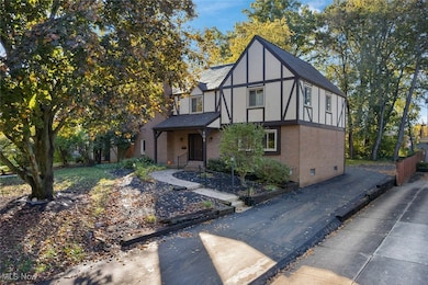 English style home with brick siding, a porch, stucco siding, and crawl space
