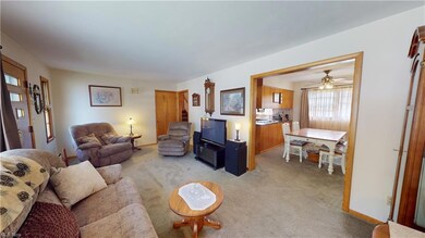 Carpeted living room with ceiling fan
