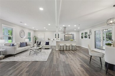 Living area with dark wood finished floors, crown 