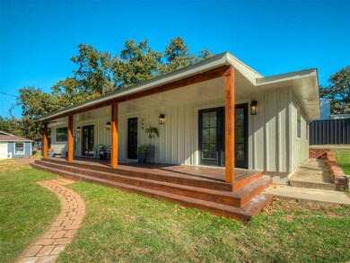Back of house featuring board and batten siding, covered porch, and a lawn