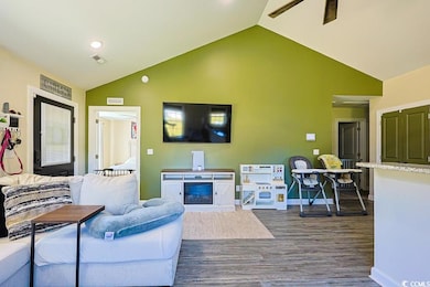 Living area with dark wood finished floors, vaulted ceiling, a ceiling fan, and recessed lighting