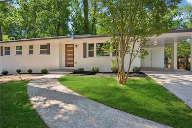 View of front of house with concrete driveway, brick siding, and an attached carport