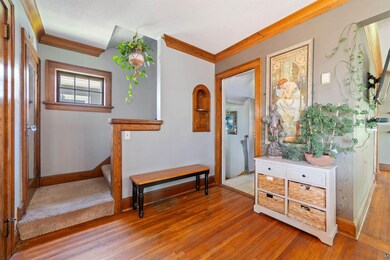 Entryway with hardwood flooring and crown molding