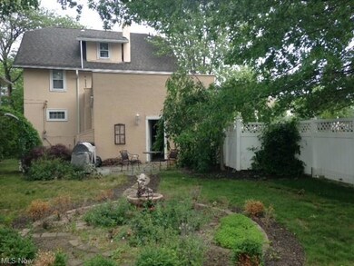 Rear view of home shows 3rd floor master bathroom window and another entryway.