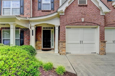Doorway to property with concrete driveway, a garage, and brick siding
