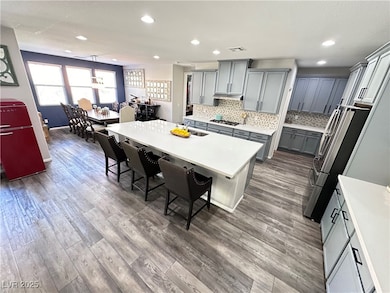 Kitchen with gray cabinets, a kitchen bar, wood fi