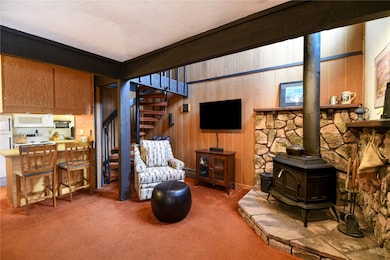 Living room with a wood stove, a textured ceiling,