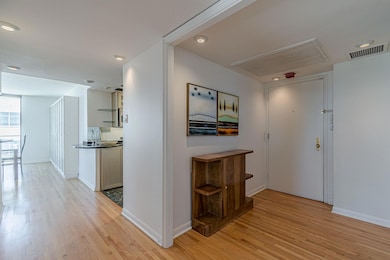 Corridor featuring light wood finished floors, attic access, and recessed lighting