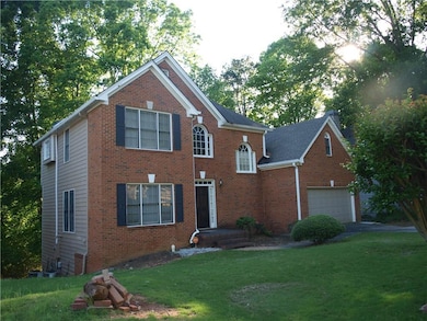 Colonial home featuring driveway, brick siding, an