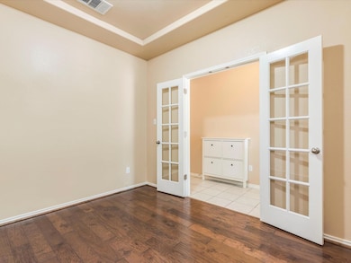 Empty room with french doors and wood finished fl