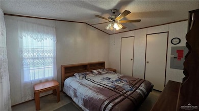Bedroom with a textured ceiling, crown molding, electric panel, and a ceiling fan