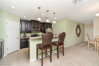 Kitchen with appliances with stainless steel finishes, light tile patterned floors, a kitchen bar, recessed lighting, and baseboards