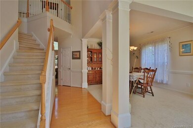 Entry with hardwood floors, open to formal room, o