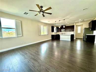 Unfurnished living room with visible vents and dar