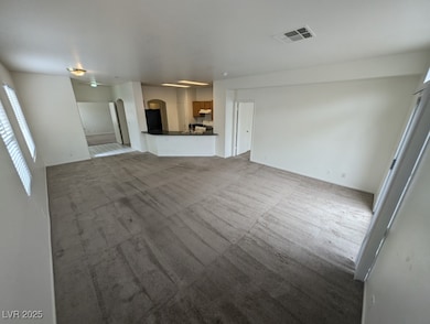 Unfurnished living room featuring a ceiling fan, c