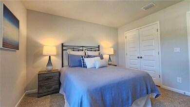 Carpeted bedroom with baseboards and a closet