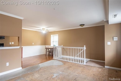 Unfurnished room featuring a wainscoted wall, crown molding, ceiling fan, and wood finished floors