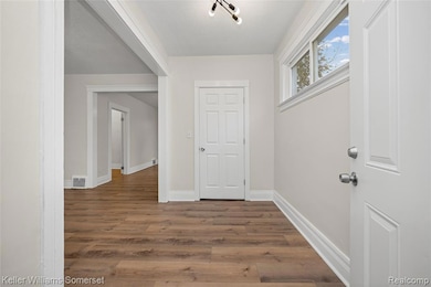Foyer entrance with wood finished floors and baseboards