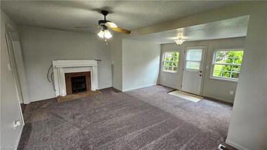 Carpeted living room featuring a textured ceiling,