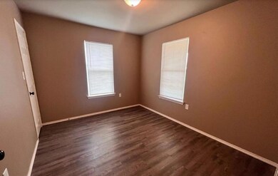 Spare room featuring dark wood-type flooring and b