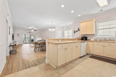 Kitchen with ornamental molding, recessed lighting, pendant lighting, a peninsula, and light tile patterned floors