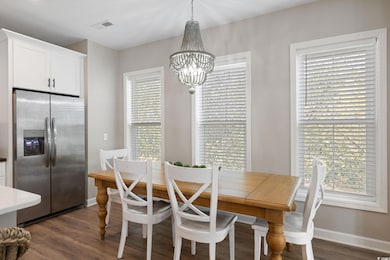 Dining space with an inviting chandelier, dark woo