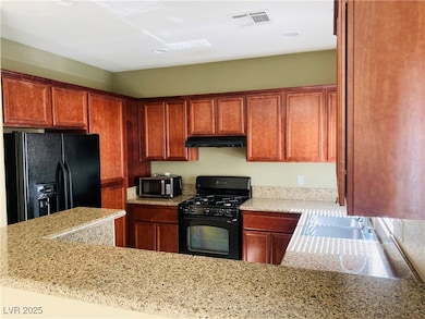 Kitchen with visible vents, brown cabinets, black