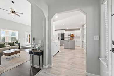 Living room featuring arched walkways, recessed lighting, light wood-type flooring, and ceiling fan