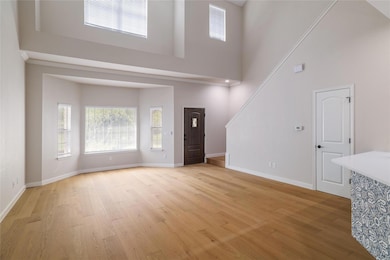 Unfurnished living room with baseboards, stairs, 