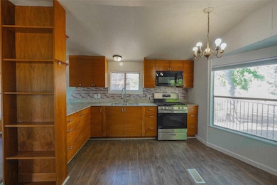 Kitchen featuring open shelves, backsplash, dark wood-style flooring, stainless steel range with gas cooktop, and brown cabinetry